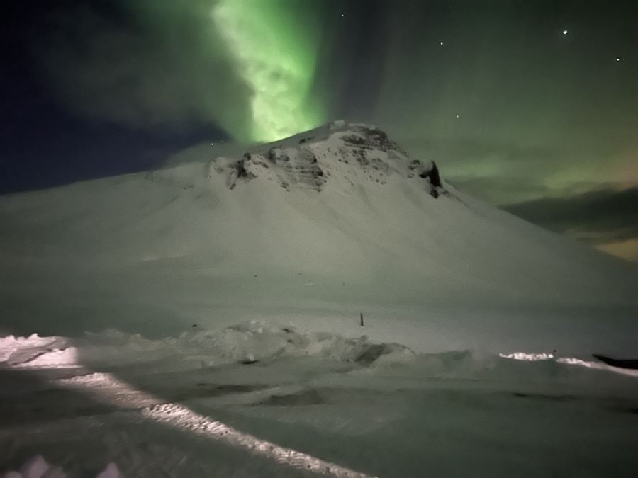 Northern lights over a snowy mountain